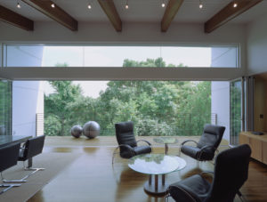 The Srygley Office Building interior shot of chairs, a table, and a railed balcony in a white airy environment