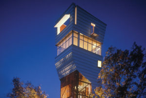 Keenan Tower House lit up at night as it towers over trees in the forest