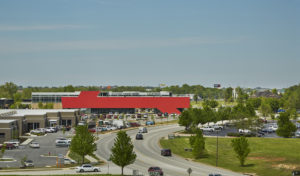 Harvey Pediatric Clinic red building face show in context of the surrounding area of busy roads and green trees