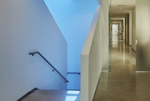 Bright white hallway and a view of the stairs below