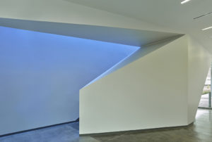 Angled staircase wall geometry detail backlit by vibrant natural light