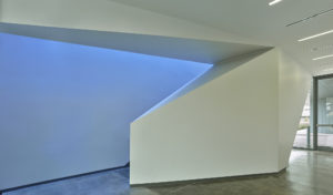 Angled staircase wall geometry detail backlit by vibrant natural light