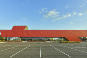 Harvey Pediatric Clinic red metal and glass profile shot looking across parking spots