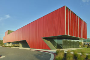 The clinic's corner showing metal cladding leaning forward as if pushing the large windows of the second floor forward in motion