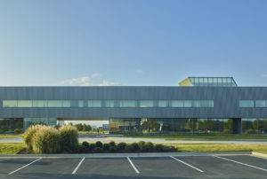 Elongated profile of the gray metal face and glass structure against the blue sky