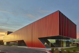 The stark color and material choice serve as a visual landmark amongst the surrounding buildings