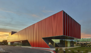 The stark color and material choice serve as a visual landmark amongst the surrounding buildings