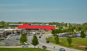 Harvey Pediatric Clinic red building face show in context of the surrounding area of busy roads and green trees