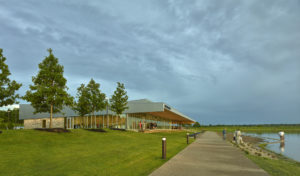 Beautiful view of the building profile seen as patron enjoy the restaurant and storm clouds brew above the structure and landscaping by the lake