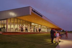 Families conversing under the building's architectural features at sunset