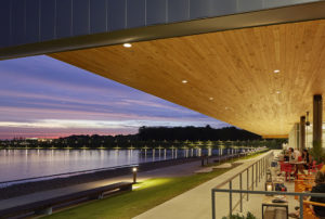 Nighttime seen from the dining room with wooden ceiling overlooking the lake water and distant city lights