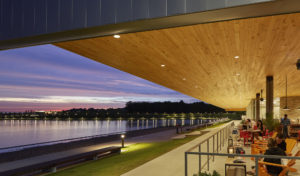 Nighttime seen from the dining room with wooden ceiling overlooking the lake water and distant city lights