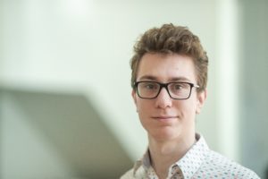 MBA team member headshot of Ethan Kaplan wearing a patterned shirt and glasses