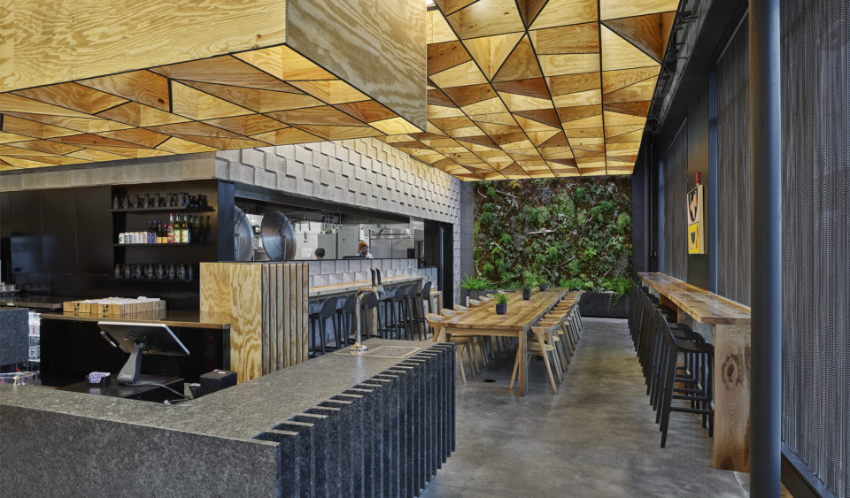The restaurant space showing a beautiful mix of materials of concrete masonry units and plywood