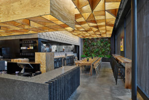 The restaurant space showing a beautiful mix of materials of concrete masonry units and plywood