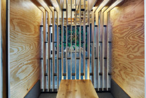 A side view of the Coop Ramen wooden booths with a view outside
