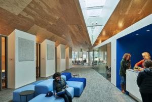 Lounge area with sharp angled ceiling above teachers gathering in the space